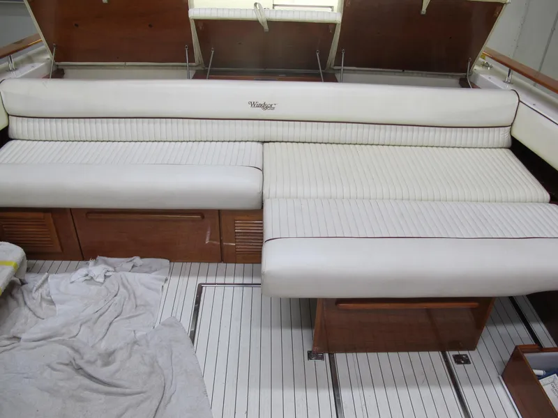 Slide: The Image of 1991 Windsor Craft 310 boat interior with white cushioned seating and wooden accents. - 14