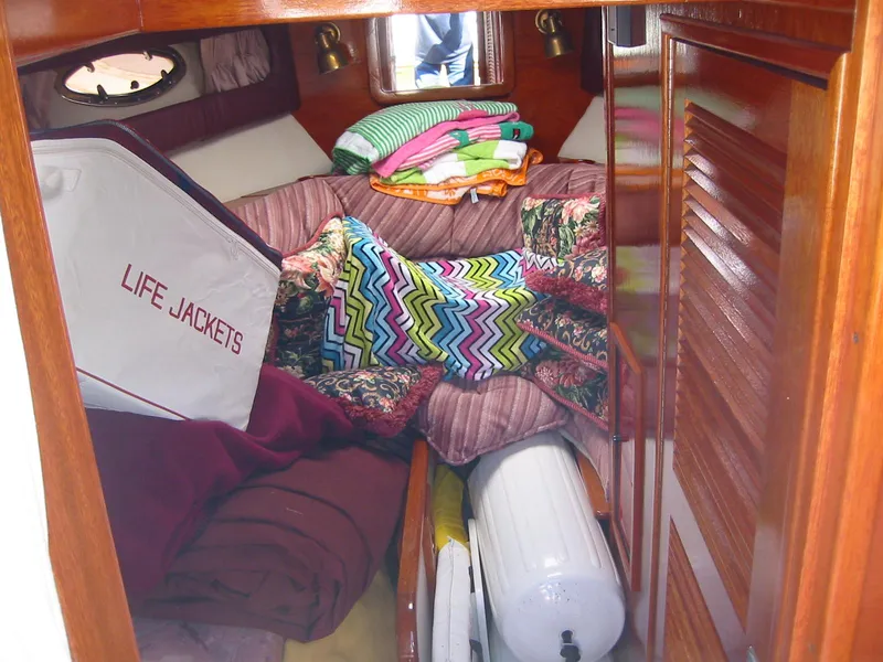 Slide: The Image of Cozy cabin interior of 1991 Windsor Craft 310 with life jackets and colorful blankets. - 16