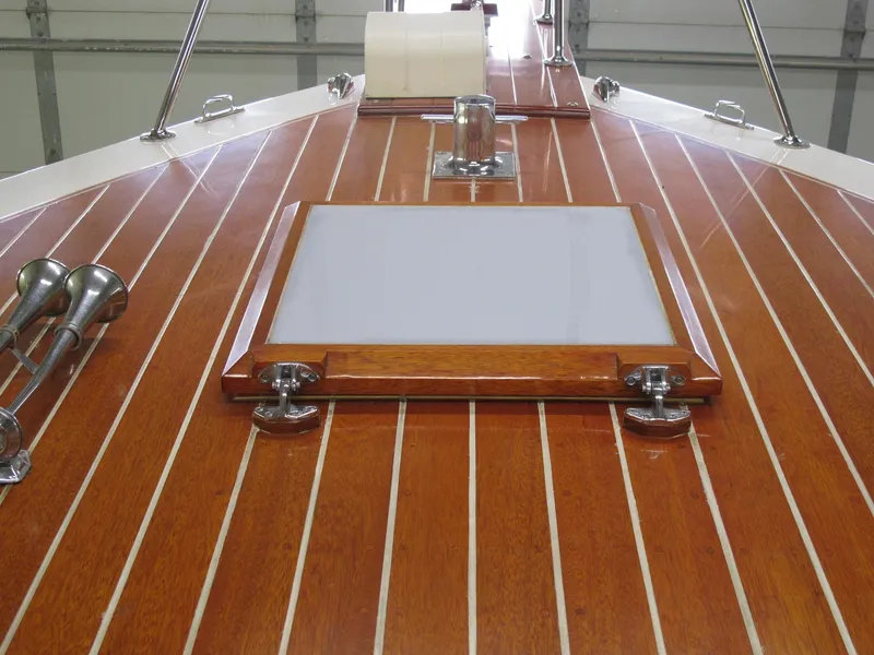 Slide: The Image of 1991 Windsor Craft 310 boat deck with polished wood finish and metal fittings. - 4