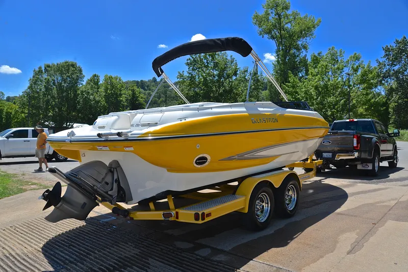Slide: The Image of 2007 Glastron GXL 235 boat on trailer, sunny day, parked near trees. - 13