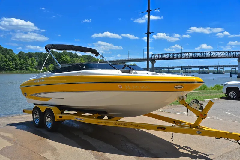 Slide: The Image of 2007 Glastron GXL 235 boat on trailer by river, under clear blue sky. - 15
