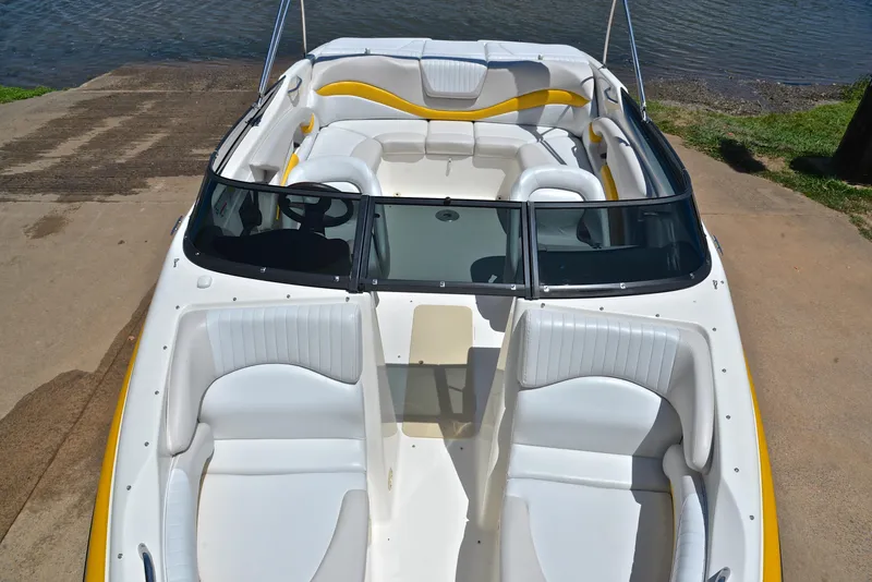 Slide: The Image of 2007 Glastron GXL 235 boat with white and yellow interior, docked near water. - 19