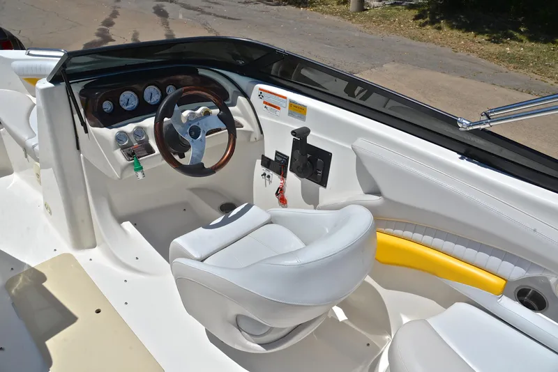 Slide: The Image of 2007 Glastron GXL 235 boat cockpit with steering wheel and white seating. - 23
