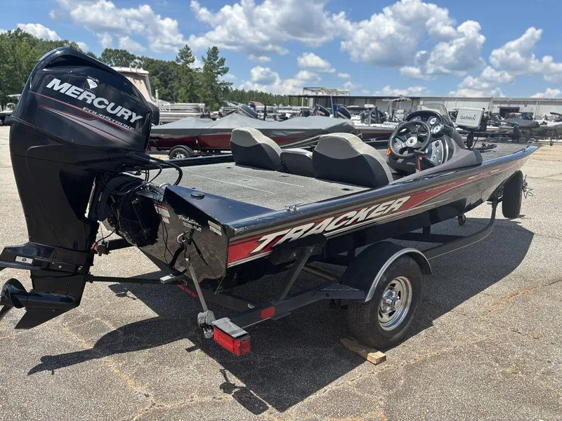 Slide: The Image of 2018 Tracker Pro Team™ 175 TXW boat with Mercury engine, parked outdoors under a blue sky. - 4