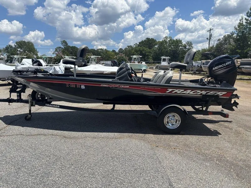 Slide: The Image of 2018 Tracker Pro Team™ 175 TXW boat on trailer, parked outdoors under a cloudy sky. - 5