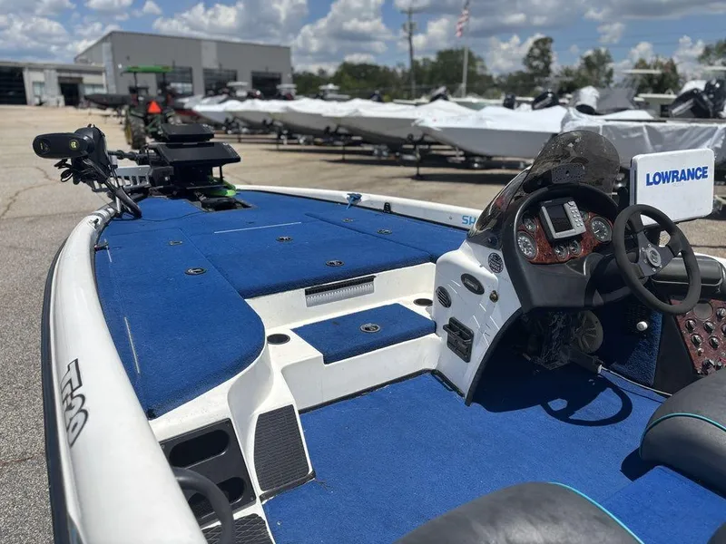 Slide: The Image of 2000 Triton TR20 boat with blue interior and Lowrance electronics, parked outdoors. - 10
