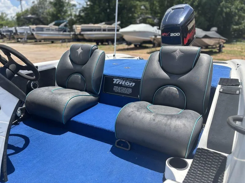Slide: The Image of 2000 Triton TR20 boat interior with blue carpet and dual seats. - 11