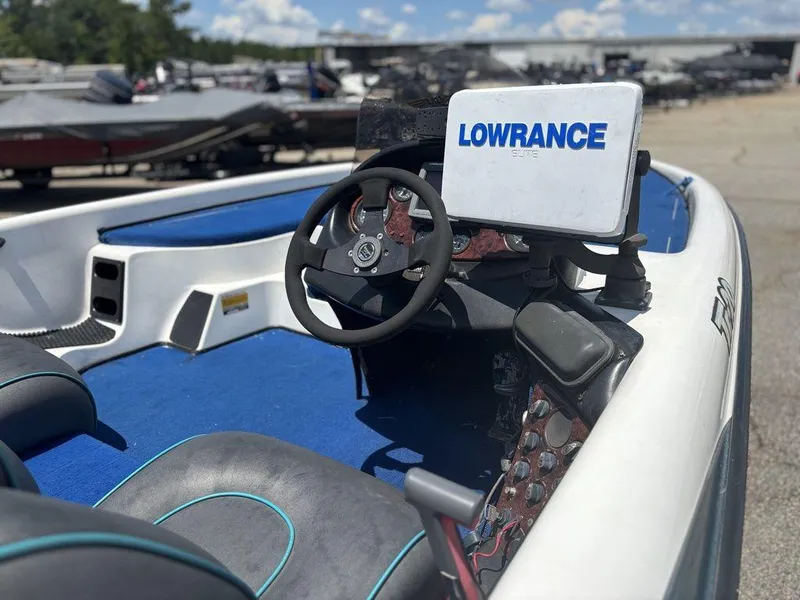 Slide: The Image of 2000 Triton TR20 boat interior with Lowrance Elite system, blue carpet, and steering wheel. - 12