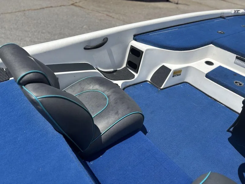 Slide: The Image of 2000 Triton TR20 boat interior with blue carpet and gray seat. - 16