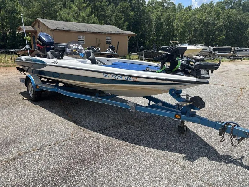 Slide: The Image of 2000 Triton TR20 boat on trailer, parked outdoors, with Yamaha outboard motor. - 3