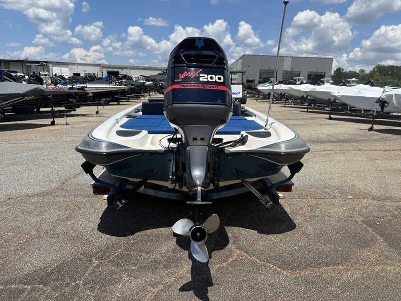 Slide: The Image of 2000 Triton TR20 boat with outboard motor in a sunny marina setting. - 4