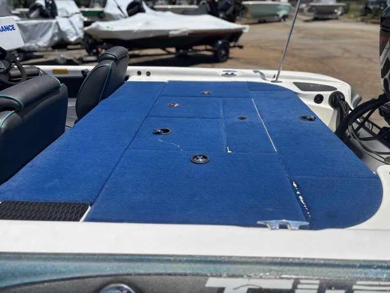 Slide: The Image of 2000 Triton TR20 boat with blue carpeted deck and seating area. - 8