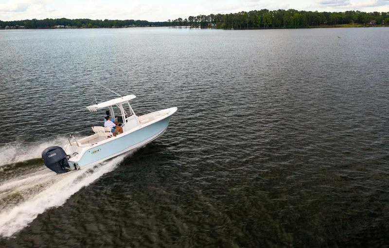 The Image of 2025 Sea Hunt Ultra 229 boat cruising on a serene lake. - 0