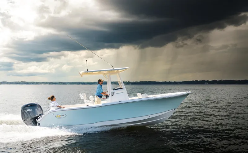 Slide: The Image of 2025 Sea Hunt Ultra 229 boat cruising under stormy skies. - 2