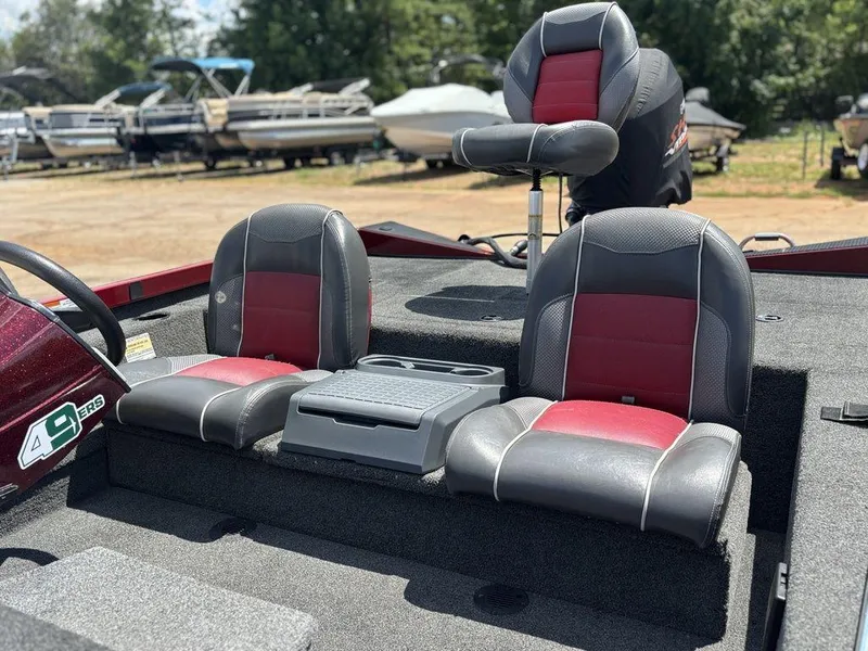 Slide: The Image of 2017 Ranger RT188 boat interior with red and gray seats, parked among other boats. - 7
