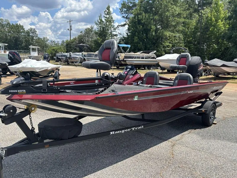 Slide: The Image of 2017 Ranger RT188 boat on trailer, parked outdoors with other boats in background. - 9