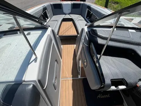 Slide: The Image of 2019 Correct Craft Nautique G 25 Super Air boat interior with gray seating and teak flooring. - 23