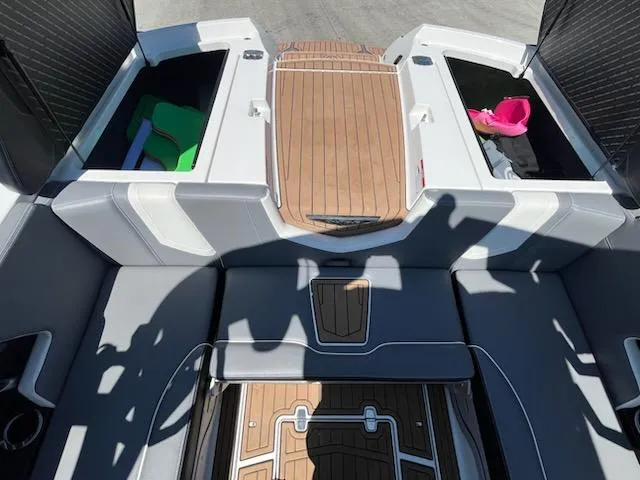 Slide: The Image of 2019 Correct Craft Nautique G 25 Super Air boat interior with storage compartments and teak flooring. - 8