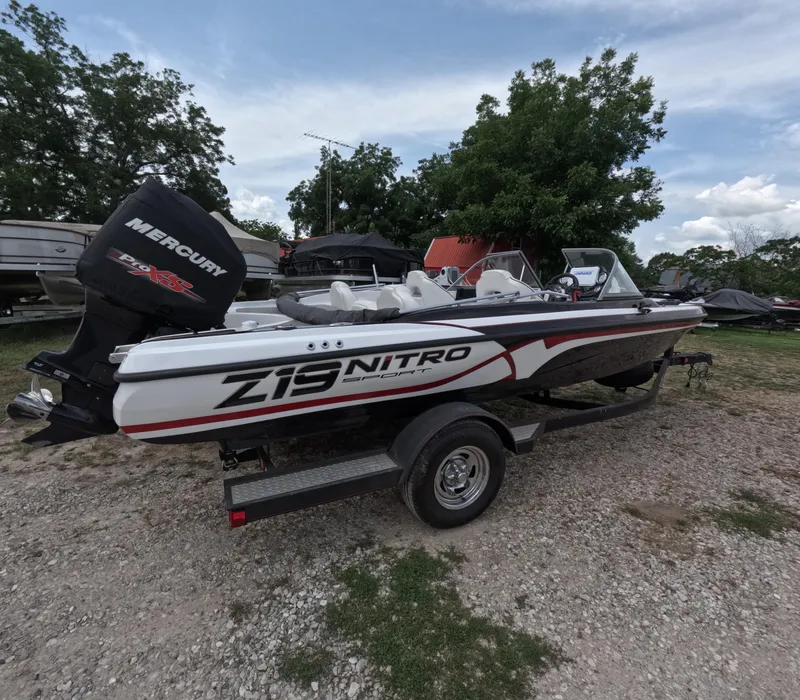 The Image of 2018 Nitro Z19 Sport boat with Mercury engine on a trailer, parked outdoors. - 0