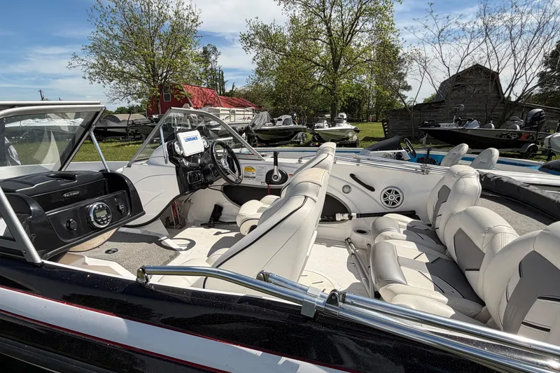 Slide: The Image of 2018 Nitro Z19 Sport boat interior with fishing equipment on grassy area. - 4