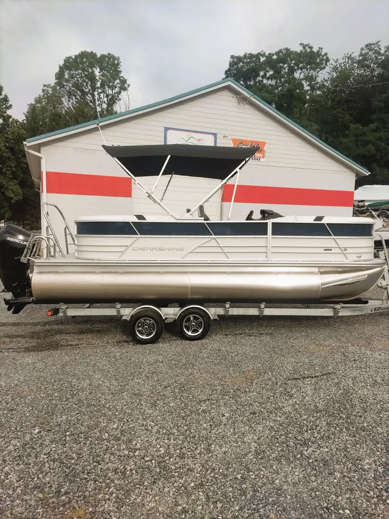 Slide: The Image of 2024 Berkshire 22RFX CTS 3.0 Performance pontoon boat on trailer, parked outside. - 9