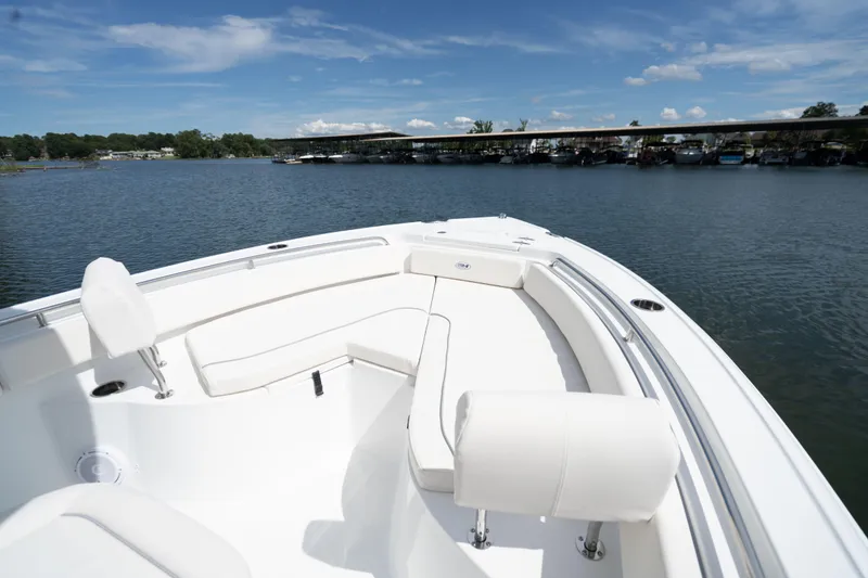 Slide: The Image of 2024 Sea Hunt Ultra 234 boat with white seating on a calm lake. - 10