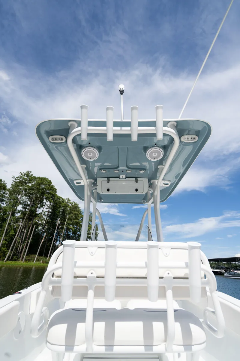 Slide: The Image of 2024 Sea Hunt Ultra 234 boat with rod holders and canopy on a sunny day. - 15