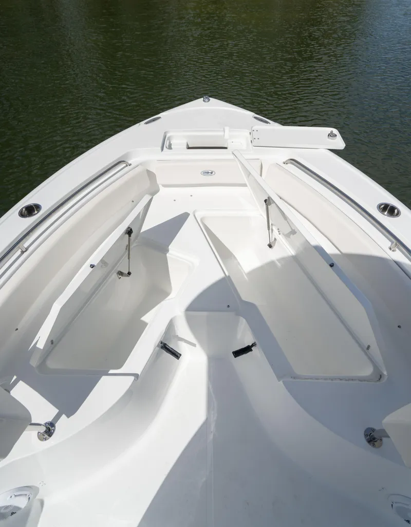Slide: The Image of 2024 Sea Hunt Ultra 234 boat bow seating area on calm water. - 22