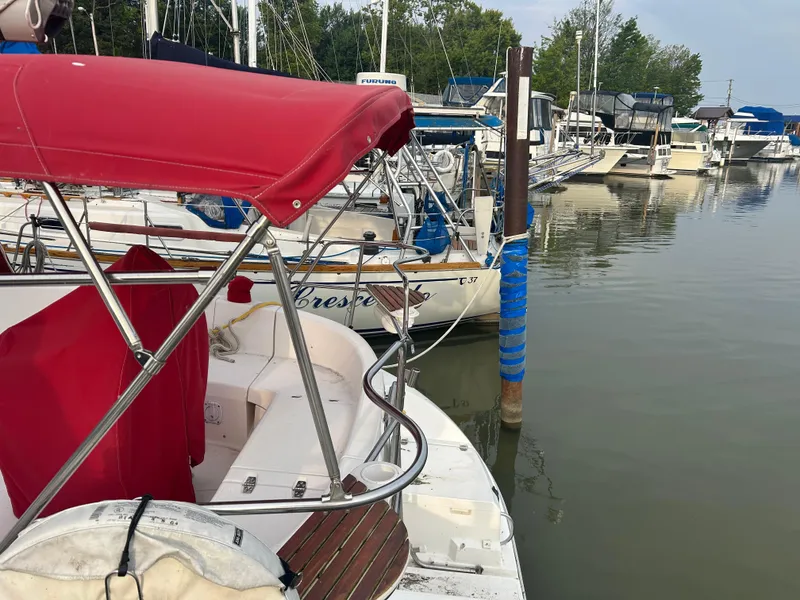 Slide: The Image of Sailboats docked at a marina, featuring a 1996 Hunter 336 with a red canopy. - 12