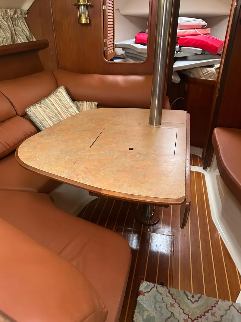 Slide: The Image of Interior of 1996 Hunter 336 sailboat with wooden table and leather seating. - 24