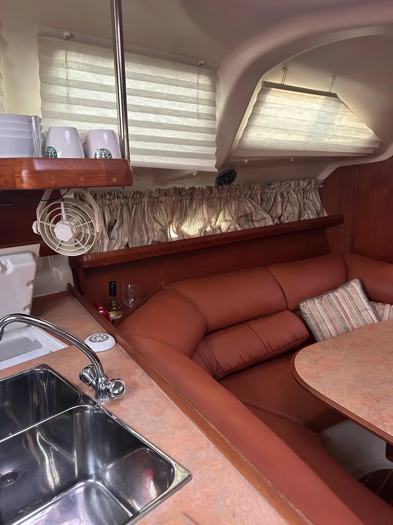 Slide: The Image of Cozy interior of a 1996 Hunter 336 sailboat with leather seating and kitchen area. - 26