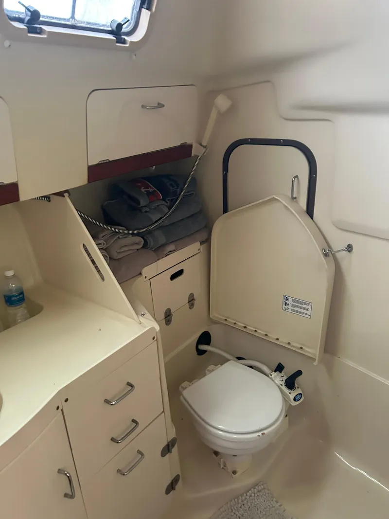 Slide: The Image of Interior of a 1996 Hunter 336 sailboat bathroom with toilet and storage cabinets. - 32