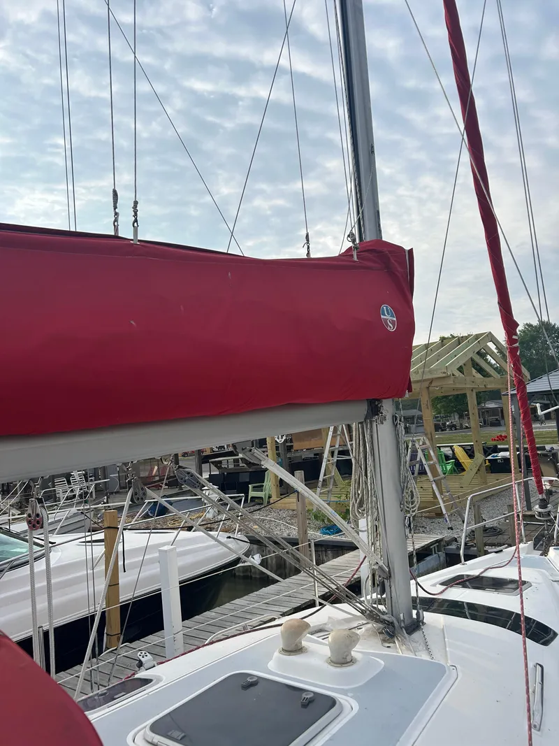 Slide: The Image of Sailboat Hunter 336, 1996 model, with red sail cover docked at marina. - 4