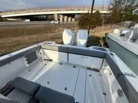 Slide: The Image of 2024 Everglades 315 Center Console boat with spacious deck, parked near a highway bridge. - 14