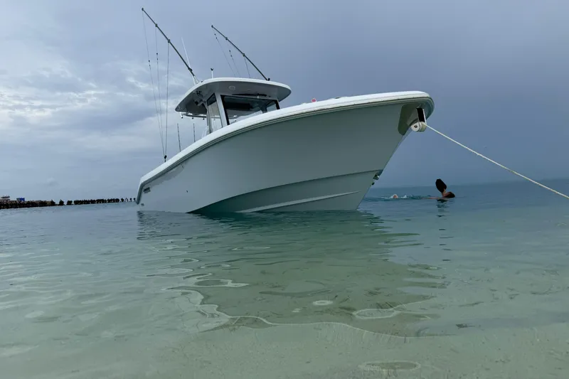 Slide: The Image of 2024 Everglades 315 Center Console boat anchored in shallow, clear water. - 17
