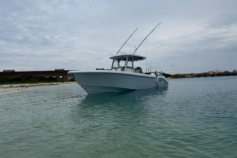 Slide: The Image of 2024 Everglades 315 Center Console boat anchored in clear coastal waters. - 19