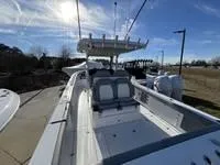 Slide: The Image of 2024 Everglades 315 Center Console boat under clear blue sky. - 2