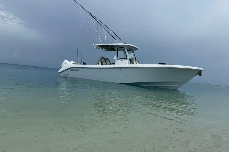 Slide: The Image of 2024 Everglades 315 Center Console boat anchored in clear, shallow water. - 21