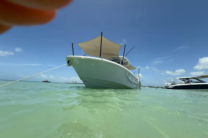 Slide: The Image of 2024 Everglades 315 Center Console boat anchored in clear turquoise water. - 25