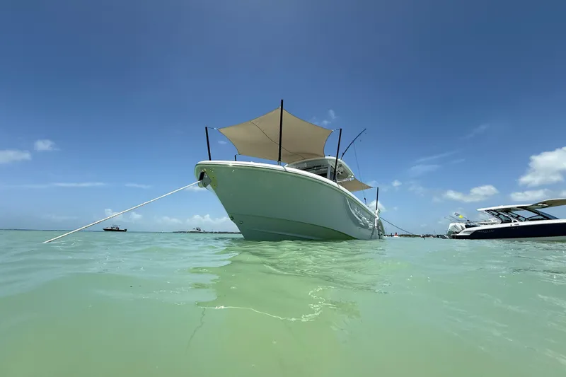 Slide: The Image of 2024 Everglades 315 Center Console boat anchored in clear turquoise water under a sunny sky. - 26