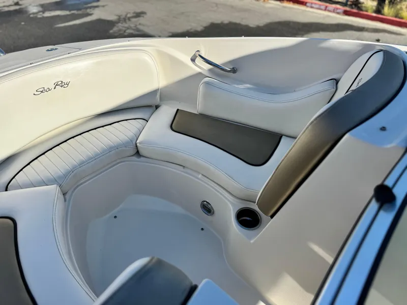 Slide: The Image of Interior seating of a 2007 Sea Ray 210 Select boat, featuring white and black upholstery. - 14