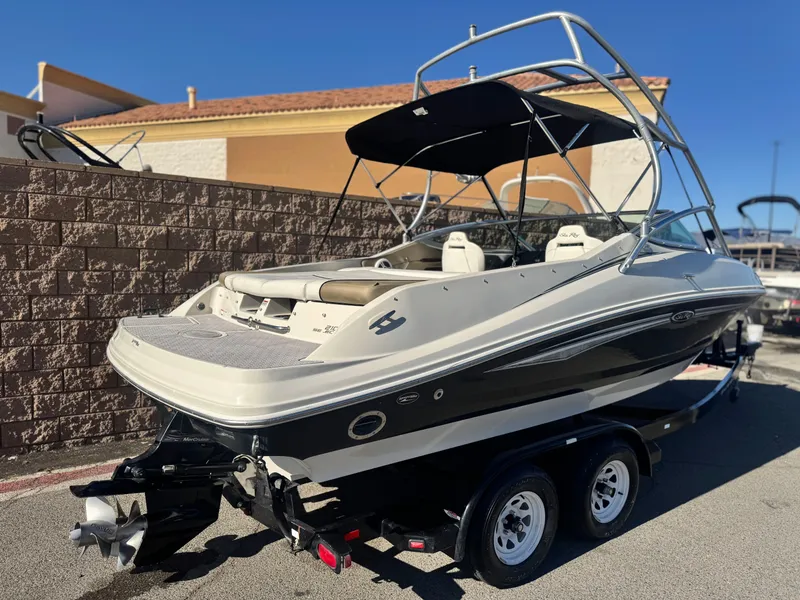 Slide: The Image of 2007 Sea Ray 210 Select boat on trailer, parked outdoors, with a sleek design and bimini top. - 5