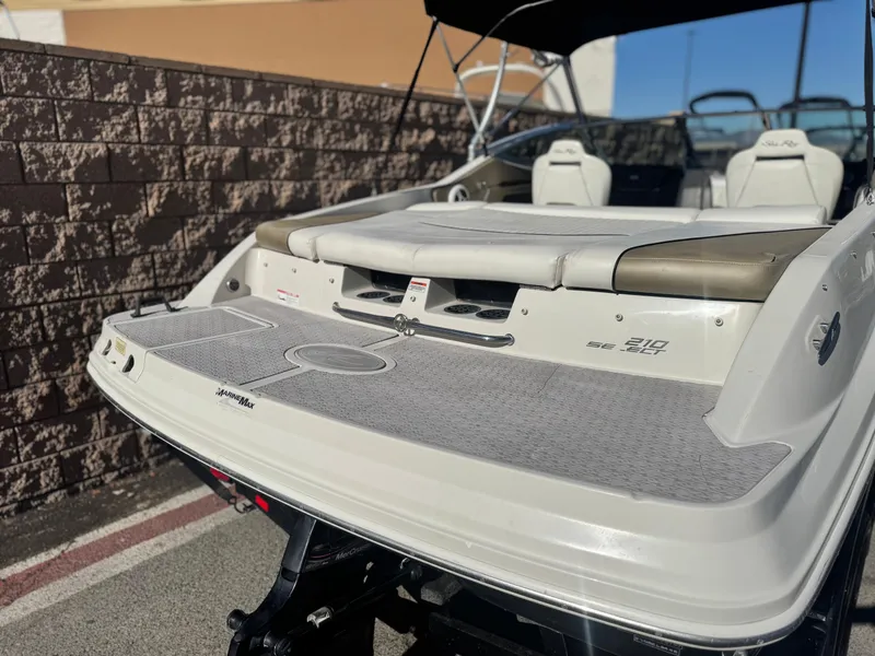 Slide: The Image of 2007 Sea Ray 210 Select boat with spacious deck and seating, parked outdoors. - 6