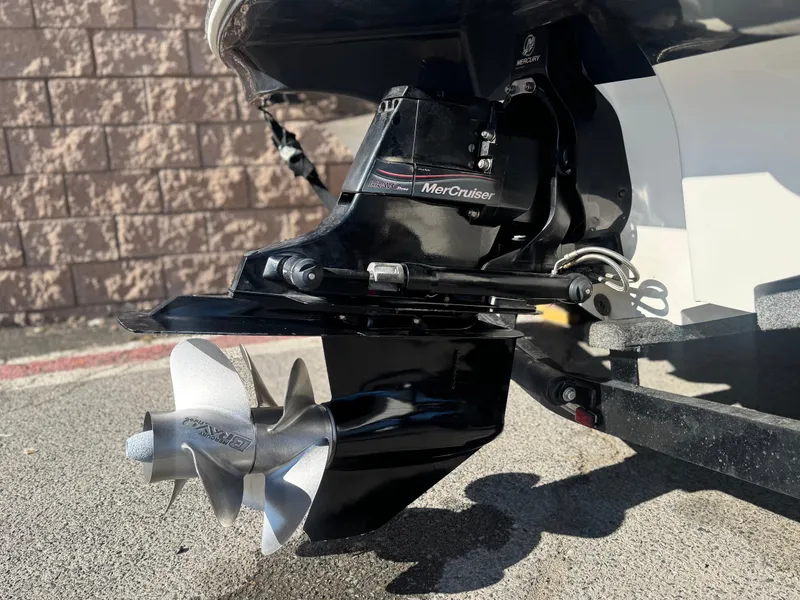 Slide: The Image of 2007 Sea Ray 210 Select MerCruiser outdrive with stainless steel propeller, parked on pavement. - 7