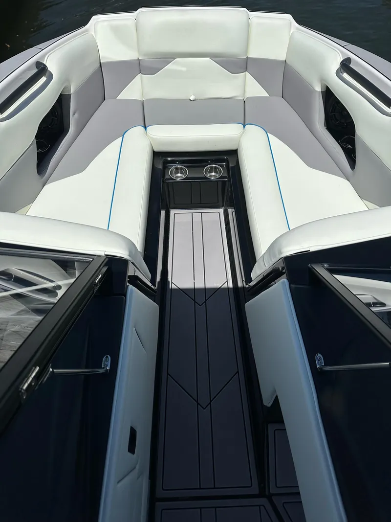 Slide: The Image of 2024 Moomba Mojo boat interior with white and gray seating, cup holders, and sleek design. - 11