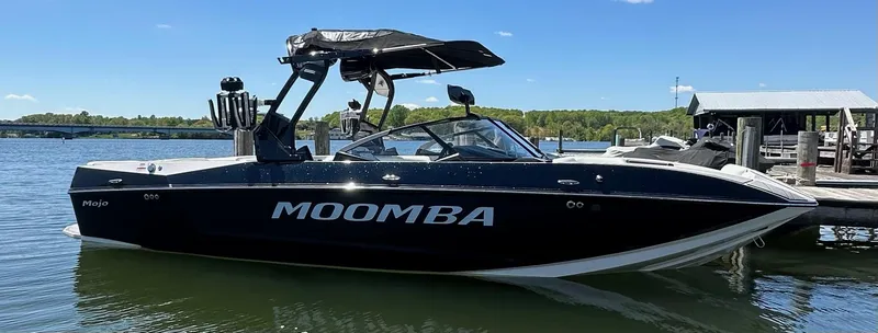 Slide: The Image of 2024 Moomba Mojo boat docked on a sunny day, showcasing sleek black design. - 3