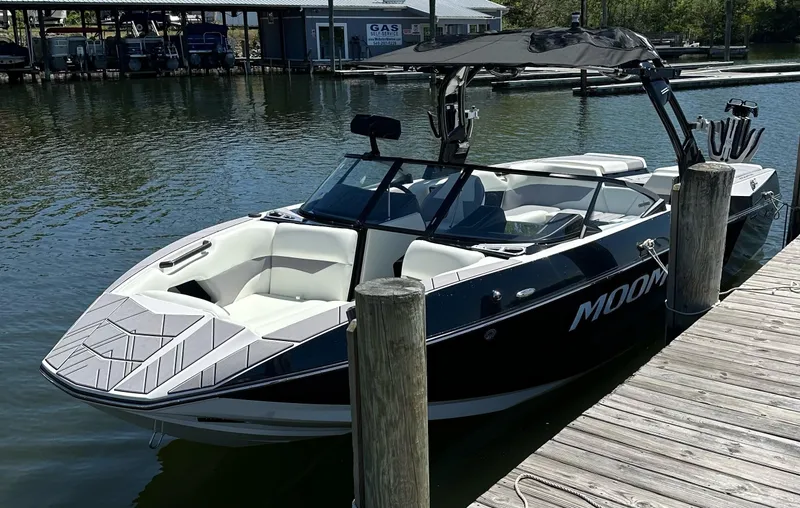 Slide: The Image of 2024 Moomba Mojo boat docked on calm water, featuring sleek design and modern amenities. - 4