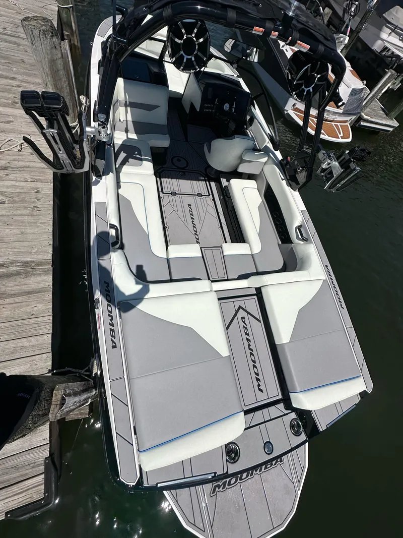 Slide: The Image of 2024 Moomba Mojo boat docked, featuring spacious seating and sleek design. - 5