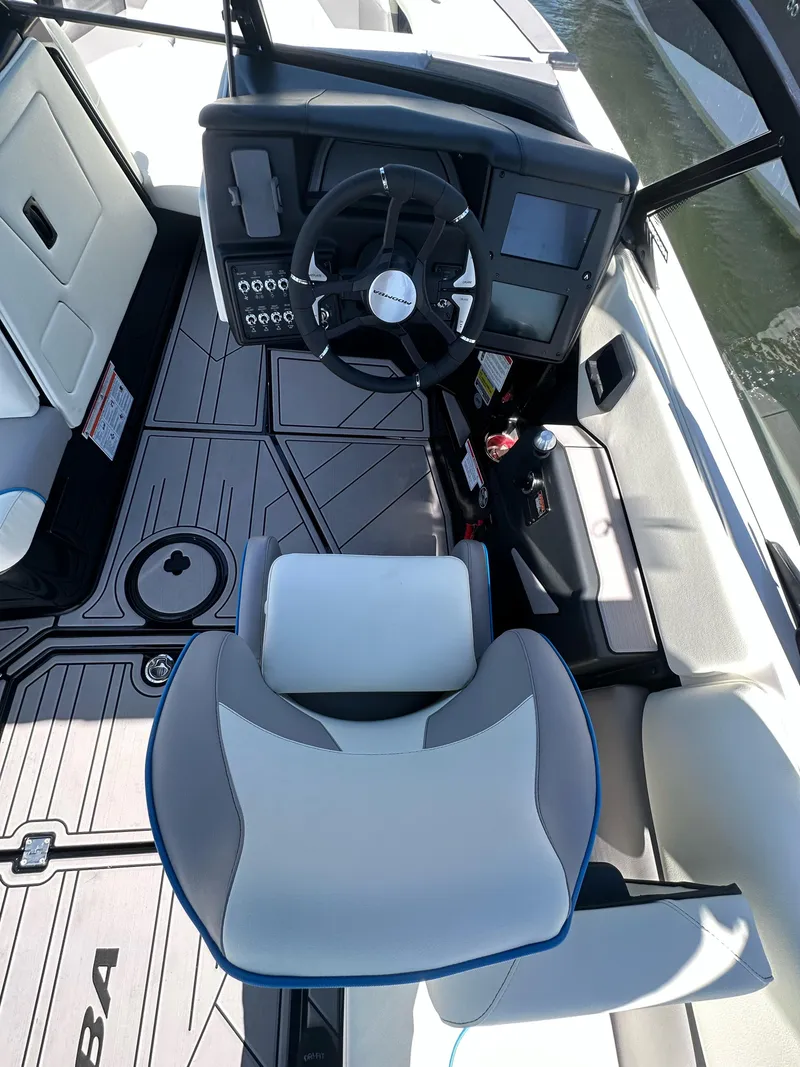Slide: The Image of 2024 Moomba Mojo boat interior with steering wheel and seating. - 8