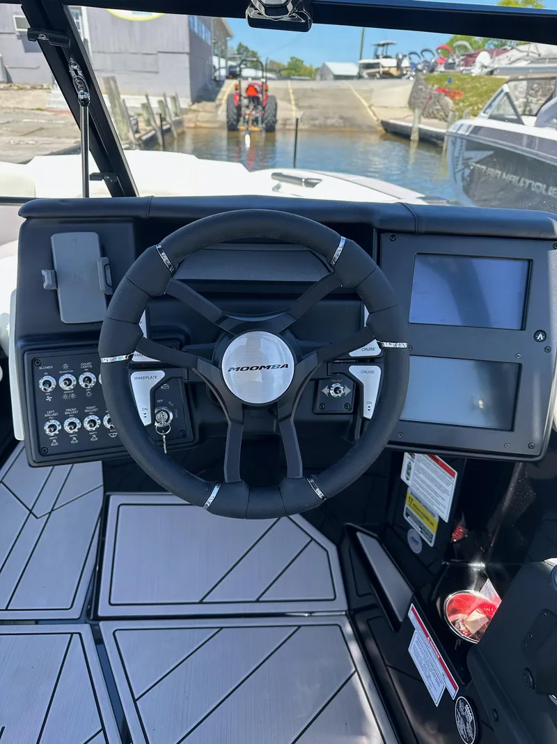 Slide: The Image of 2024 Moomba Mojo boat dashboard with steering wheel and control panel. - 9